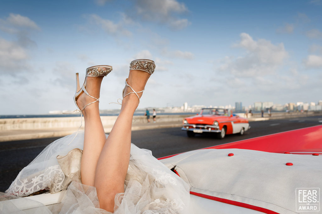 fearless award wedding photos. Zapatos de Novia en auto rojo en el Malecón de La Habana.