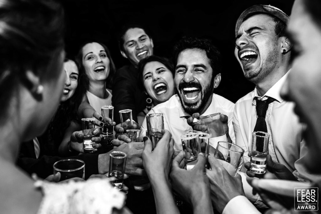 fearless award wedding photos. Novia brinda con sus amigos con muchas risas. Foto en blanco y negro