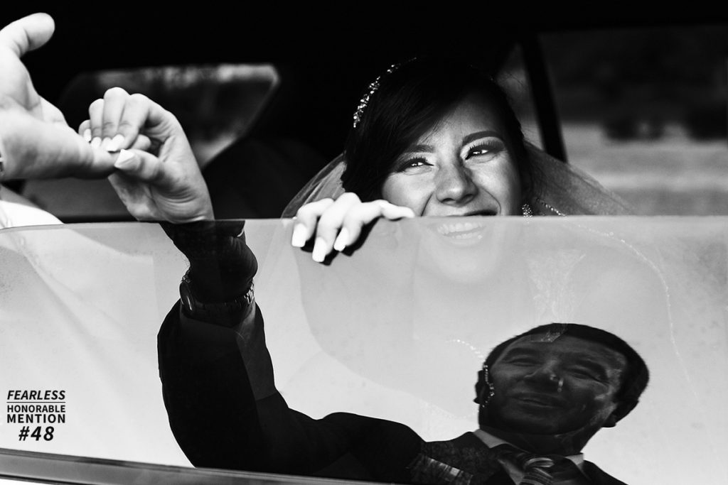 fearless award wedding photos. Novia sonriente en auto y reflejo de su padre en la ventana. Foto en blanco y negro