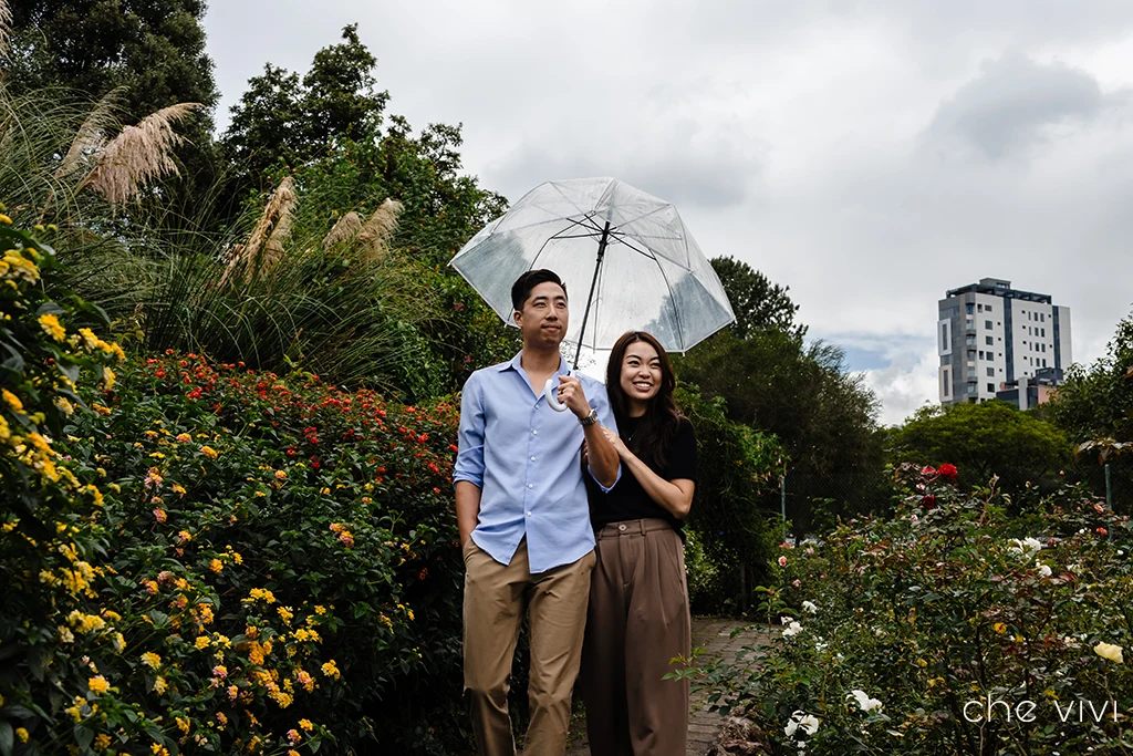 Pareja asiática caminando con una sombrilla por Jardín Botánico de Quito