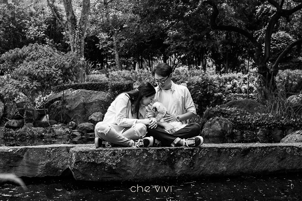 Pareja con su perro Shih Tzu en jardín con agua Quito