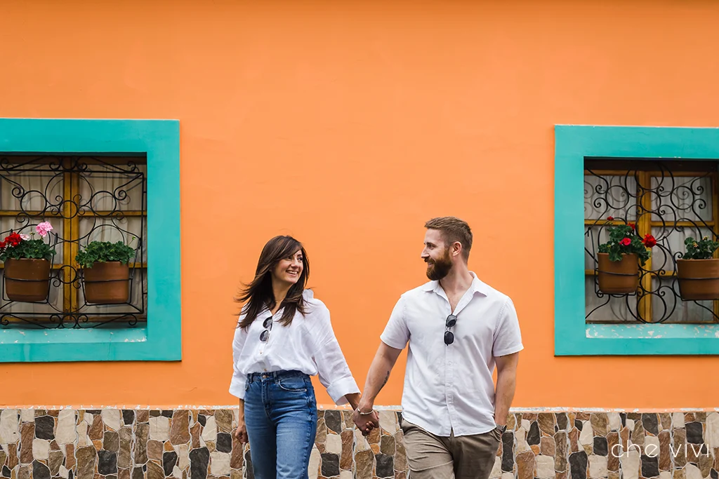 Pareja sonriendo y una pared de casa colonial colorida Quito