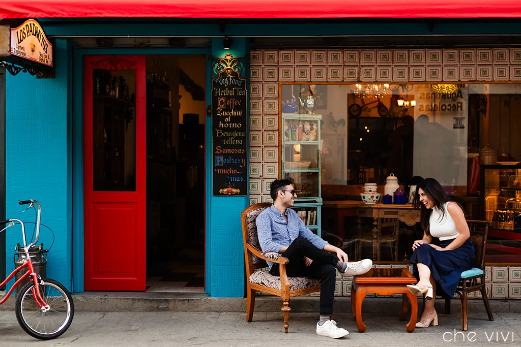 Pareja sentada en las afueras de una cafetería vintage del centro histórico de Quito