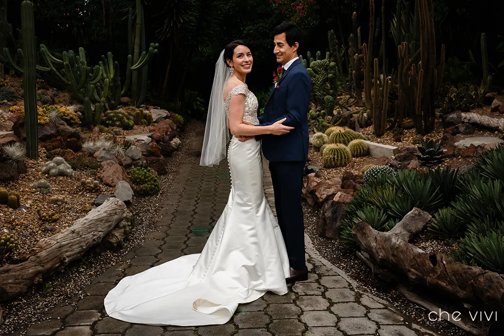 Pareja de novia y novio en jardín botánico con cactus.