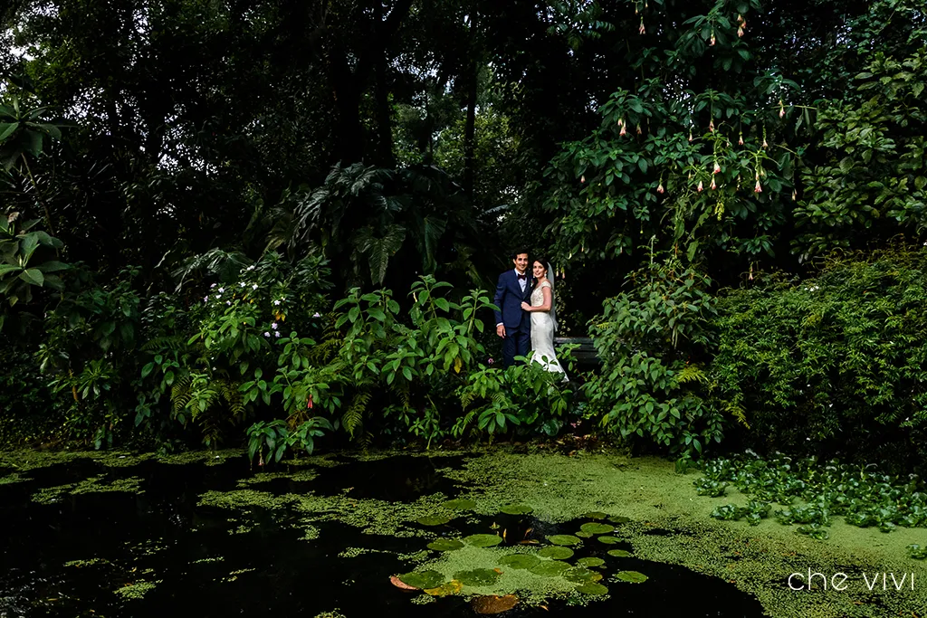 Recién casado rodeados de árboles y vegetación del jardín de Quito.