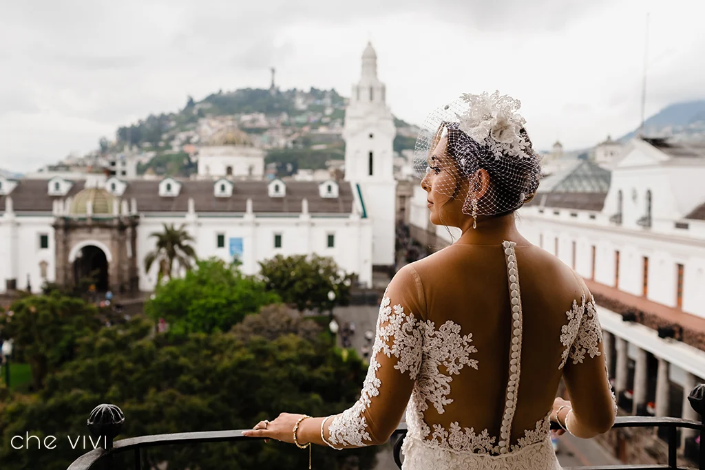 Novia en balcón del Hotel Plaza Grande y de fondo el Panecillo