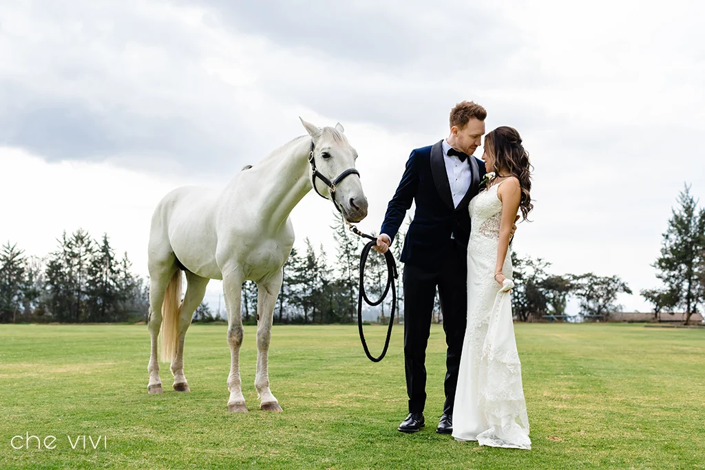 Pareja junto a caballo blanco en cancha de La Palma Polo Club Puembo